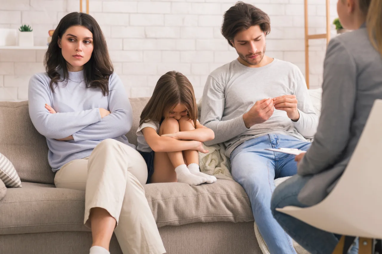 A family sitting together in warm light, looking connected and hopeful.