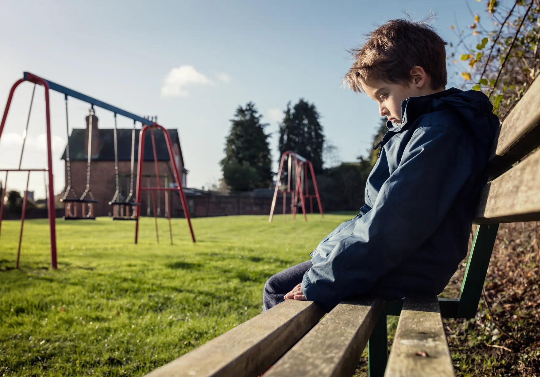 A parent and child sitting together on a couch, talking through a difficult moment.