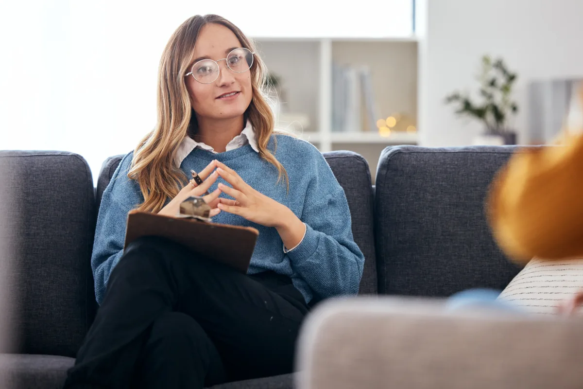 Psychologist with a clipboard talking with a client during a diagnostic evaluation session
